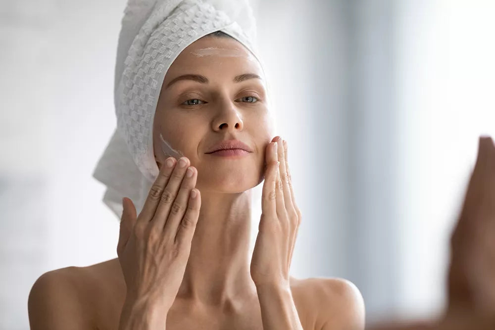 Woman applying moisturiser as part of a simple skincare routine